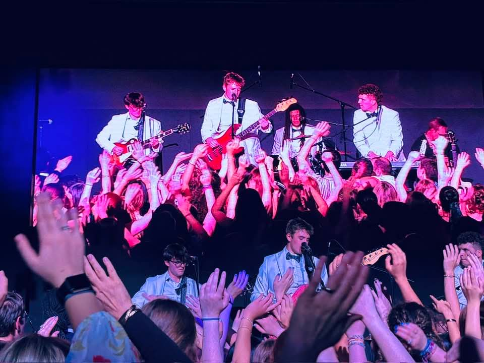 Better Than Nothing performs at Rockway’s BIG Night Out as audience members raise their hands in front of the stage.
