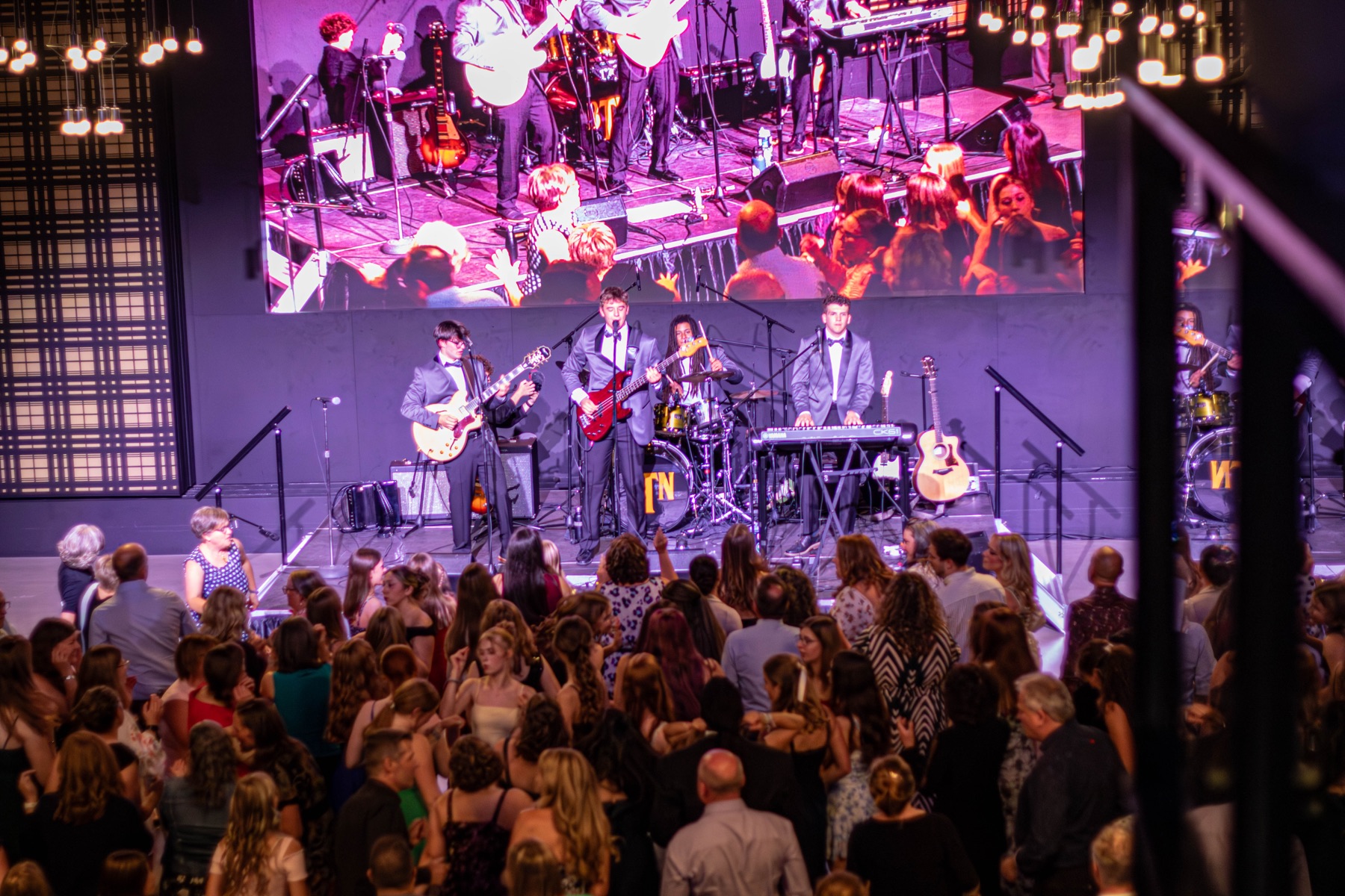 Better Than Nothing performing on stage above a dancing crowd at Tapestry Hall.